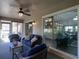Covered lanai featuring wicker seating, ceiling fan, and a large glass window into the home's living room at 1914 Armondo Dr, The Villages, FL 32159
