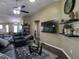Open-concept living area with a dark leather sofa, glass coffee table, and mounted TV at 1914 Armondo Dr, The Villages, FL 32159