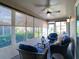 Enclosed sunroom with comfortable seating and large windows offering bright natural light at 1914 Armondo Dr, The Villages, FL 32159