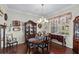 Dining room with a traditional-style table, china cabinet, hardwood floors, and a decorative chandelier at 19624 Spring Oak Dr, Eustis, FL 32736