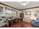 Cozy living room showcases a wooden desk, chair, bookshelf, and comfortable seating arrangement bathed in natural light at 19624 Spring Oak Dr, Eustis, FL 32736