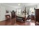 Well-appointed main bedroom with hardwood floors, a four-poster bed, and ample natural light at 19624 Spring Oak Dr, Eustis, FL 32736