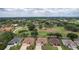 Aerial view showcasing a neighborhood with golf course views and tree-lined streets at 1972 Palo Alto Ave, The Villages, FL 32159