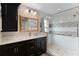 Updated bathroom featuring glass enclosed shower with pebble floor and dark cabinets at 1972 Palo Alto Ave, The Villages, FL 32159