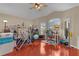 Large bonus room with ceiling fan, hardwood floors, and multiple windows for plenty of natural light at 1972 Palo Alto Ave, The Villages, FL 32159