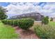 Exterior view of a home with a screen-enclosed pool and landscaped garden at 1972 Palo Alto Ave, The Villages, FL 32159