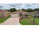 Attractive single-story home featuring a brick driveway, manicured lawn, and mature landscaping at 1972 Palo Alto Ave, The Villages, FL 32159