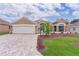 Charming single-story home boasts a well-manicured lawn, brick driveway, and attached two-car garage at 1972 Palo Alto Ave, The Villages, FL 32159