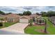 Well-maintained home features a brick driveway, two-car garage, manicured lawn, and charming front garden beds at 1972 Palo Alto Ave, The Villages, FL 32159