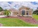 Single-story home with a well-manicured lawn, brick driveway and meticulous landscaping at 1972 Palo Alto Ave, The Villages, FL 32159