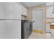 A spacious laundry room featuring modern washer and dryer, white cabinets and tile floors at 1972 Palo Alto Ave, The Villages, FL 32159