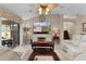 Bright living room with white furniture, decorative ceiling fan, and large sliding glass doors to the patio at 1972 Palo Alto Ave, The Villages, FL 32159