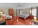 Spacious main bedroom features dark wood floors, a four-poster bed, and a sitting area by the windows at 1972 Palo Alto Ave, The Villages, FL 32159