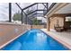 Private screened pool featuring a waterfall and an outdoor seating area for entertaining at 1972 Palo Alto Ave, The Villages, FL 32159