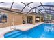 Inviting screened-in pool with a spa, steps, and an adjacent outdoor seating area at 1972 Palo Alto Ave, The Villages, FL 32159