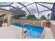 Sparkling pool inside a screened enclosure with a waterfall feature and surrounding patio at 1972 Palo Alto Ave, The Villages, FL 32159