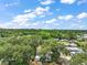Aerial view of a charming community with mature trees offering shaded landscapes under a sunny blue sky at 2110 Oak Cir, Mount Dora, FL 32757