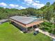 Aerial view of a community clubhouse with a golf cart parked nearby, surrounded by lush greenery at 2110 Oak Cir, Mount Dora, FL 32757