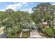Aerial view of a charming home nestled among mature trees, showcasing its curb appeal and serene setting at 2110 Oak Cir, Mount Dora, FL 32757