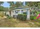 Well-maintained home exterior with blue shutters, mature landscaping, and a visible air conditioning unit at 2110 Oak Cir, Mount Dora, FL 32757