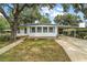 Charming single-story home with a covered carport, complemented by a well-manicured lawn and mature trees at 2110 Oak Cir, Mount Dora, FL 32757