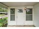 Inviting front door with glass accents, flanked by windows, on a charming home's porch at 2110 Oak Cir, Mount Dora, FL 32757