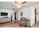 Cozy living room with wood-look floors, a ceiling fan, and a view towards other living areas at 2110 Oak Cir, Mount Dora, FL 32757