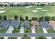 An aerial view of a home with a golf course behind it and several neighborhood homes at 2120 Willow Grove Way, The Villages, FL 32162