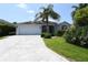 Charming single-story home featuring a spacious driveway, lush landscaping, and a welcoming two-car garage at 2120 Willow Grove Way, The Villages, FL 32162