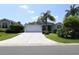 Charming single-story home featuring a spacious driveway, lush landscaping, and a welcoming two-car garage at 2120 Willow Grove Way, The Villages, FL 32162