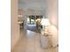 Inviting hallway featuring tile flooring, decorative lamps, and a glimpse into the bright and airy living spaces at 2120 Willow Grove Way, The Villages, FL 32162