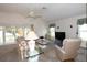 Comfortable living room featuring plush seating, ceiling fan, and large windows offering ample natural light at 2120 Willow Grove Way, The Villages, FL 32162