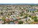 Wide aerial shot of a dense neighborhood with houses, streets, trees, and a small body of water in the distance at 2202 Kershaw Rd, The Villages, FL 32162