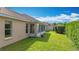 A well-maintained backyard featuring green grass, a screen enclosed back porch, and lush hedges creating a private outdoor space at 2202 Kershaw Rd, The Villages, FL 32162