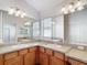 Bathroom with double sinks, wooden cabinets, and a large mirror at 2202 Kershaw Rd, The Villages, FL 32162