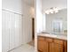 Bathroom features a vanity with wood cabinets, a sink, a mirror, and tiled floors, offering style and functionality at 2202 Kershaw Rd, The Villages, FL 32162