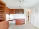 Spacious bedroom featuring wooden cabinets, a built-in desk, and a ceiling fan, offering comfort and functionality at 2202 Kershaw Rd, The Villages, FL 32162