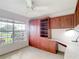 Bedroom featuring custom built-in desk and shelves with exterior view from the window at 2202 Kershaw Rd, The Villages, FL 32162