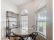 Bright dining room features large windows, marble table, and bar with wine storage at 2202 Kershaw Rd, The Villages, FL 32162