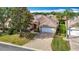 Lovely single story home featuring a brick driveway, two car garage, mature landscaping, and a well manicured lawn at 2202 Kershaw Rd, The Villages, FL 32162