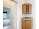 Hallway featuring a corner cabinet with glass door and view into a bedroom at 2202 Kershaw Rd, The Villages, FL 32162