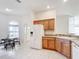 Open concept kitchen adjacent to dining area with stainless steel appliances and wood cabinetry at 2202 Kershaw Rd, The Villages, FL 32162