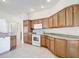 Well-lit kitchen boasts wood cabinets, white appliances, and tile flooring at 2202 Kershaw Rd, The Villages, FL 32162
