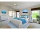 Staged main bedroom with king bed, soft blue accents, ceiling fan, and sliding doors to the outdoor patio at 2202 Kershaw Rd, The Villages, FL 32162