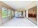 Spacious sunroom with tile floors, multiple windows, a ceiling fan, and easy access to both the backyard and dining room at 2202 Kershaw Rd, The Villages, FL 32162
