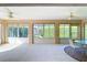 Bright sunroom featuring tile flooring, ceiling fans, and an array of large windows, creating a sun-filled, inviting space at 2202 Kershaw Rd, The Villages, FL 32162