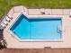 Aerial view of a community swimming pool surrounded by lounge chairs and a secure fence at 2242 Orkney Dr, Leesburg, FL 34788