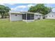 Exterior backyard view of house with screened in porch at 2242 Orkney Dr, Leesburg, FL 34788