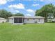 Exterior backyard view of house with screened in porch at 2242 Orkney Dr, Leesburg, FL 34788