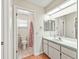 Well-lit bathroom with white cabinets, tile floor, and a shower at 2242 Orkney Dr, Leesburg, FL 34788